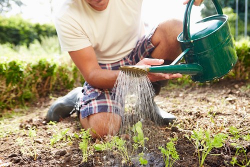 Professional landscapers working on a modern garden in Hornsey with vertical gardens and efficient irrigation.